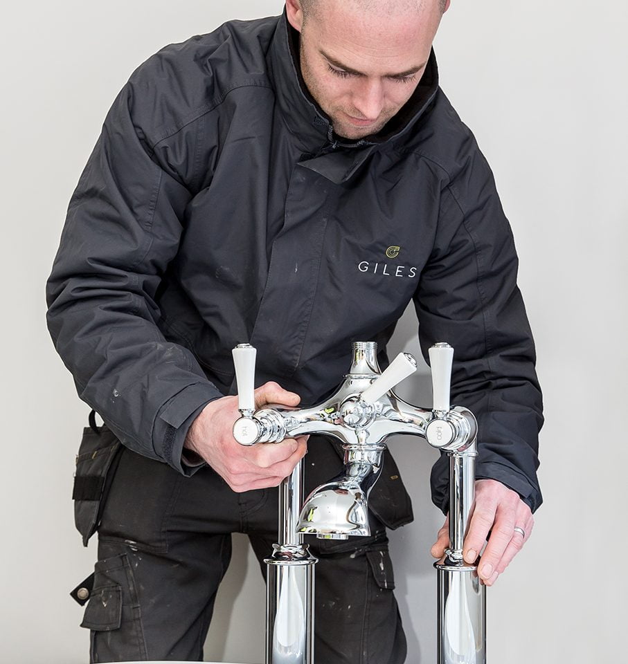 A Giles Group Plumber installing a bathroom tap